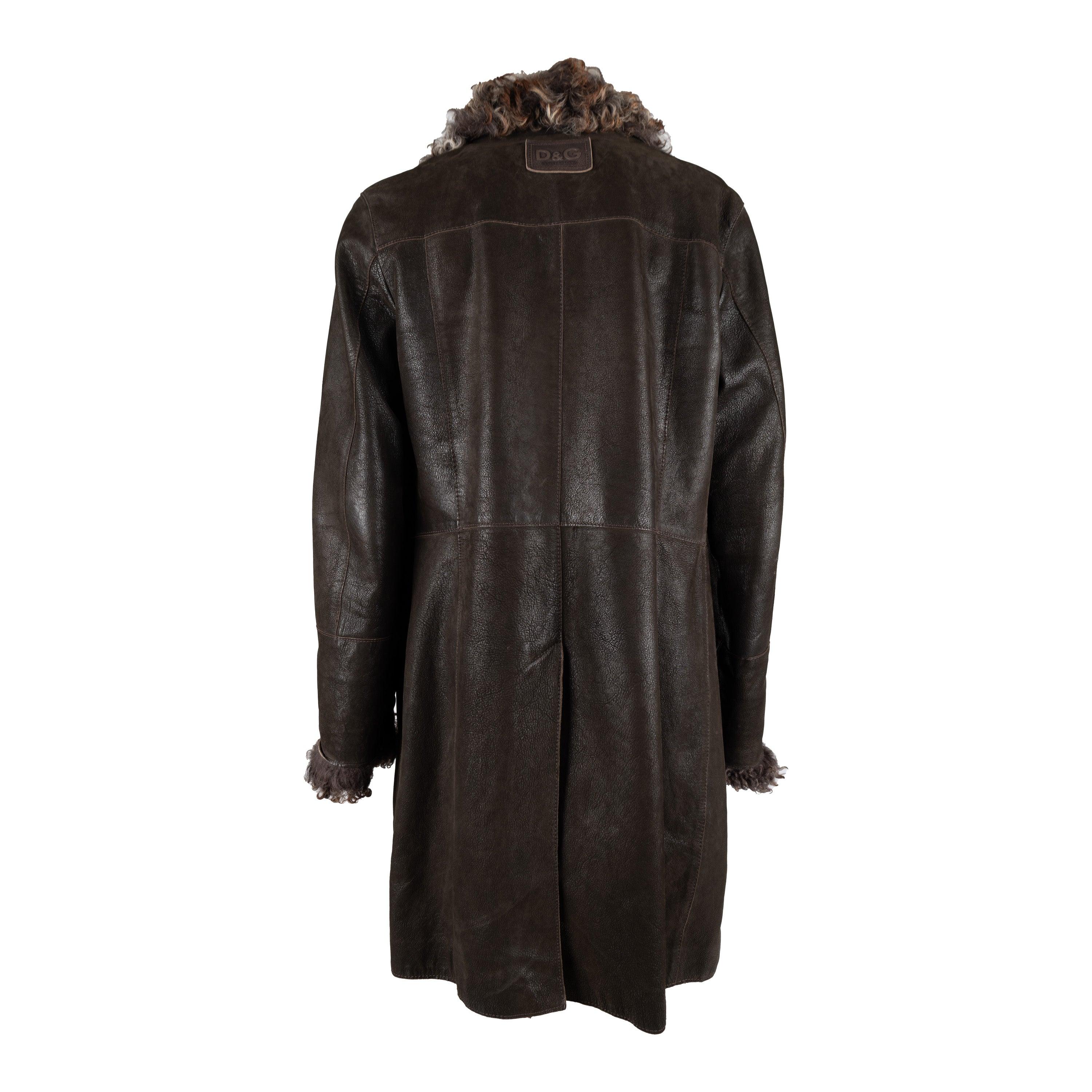 Made from dark brown leather, this Dolce & Gabbana jacket boasts a long silhouette and features a double breasted design. The luxurious fur on the collar and sleeve hem, along with the checkered viscose fabric lining, add a touch of elegance to this