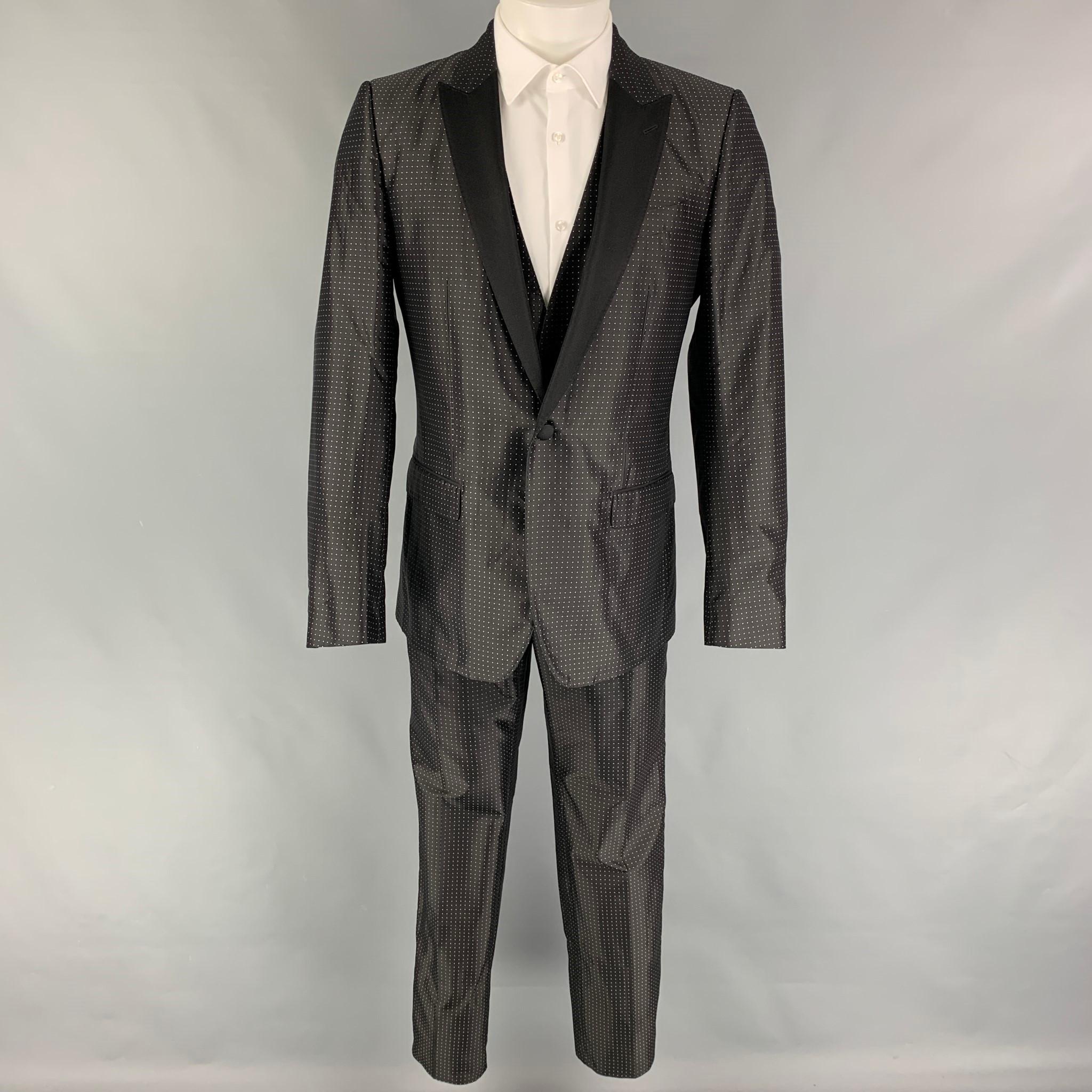 DOLCE & GABBANA 'Martini' 3 Piece suit comes in a black & white dot print silk / polyester with a full liner and includes a single breasted, single button sport coat with a peak lapel and a matching vest & flat front trousers. Made in Italy.

New