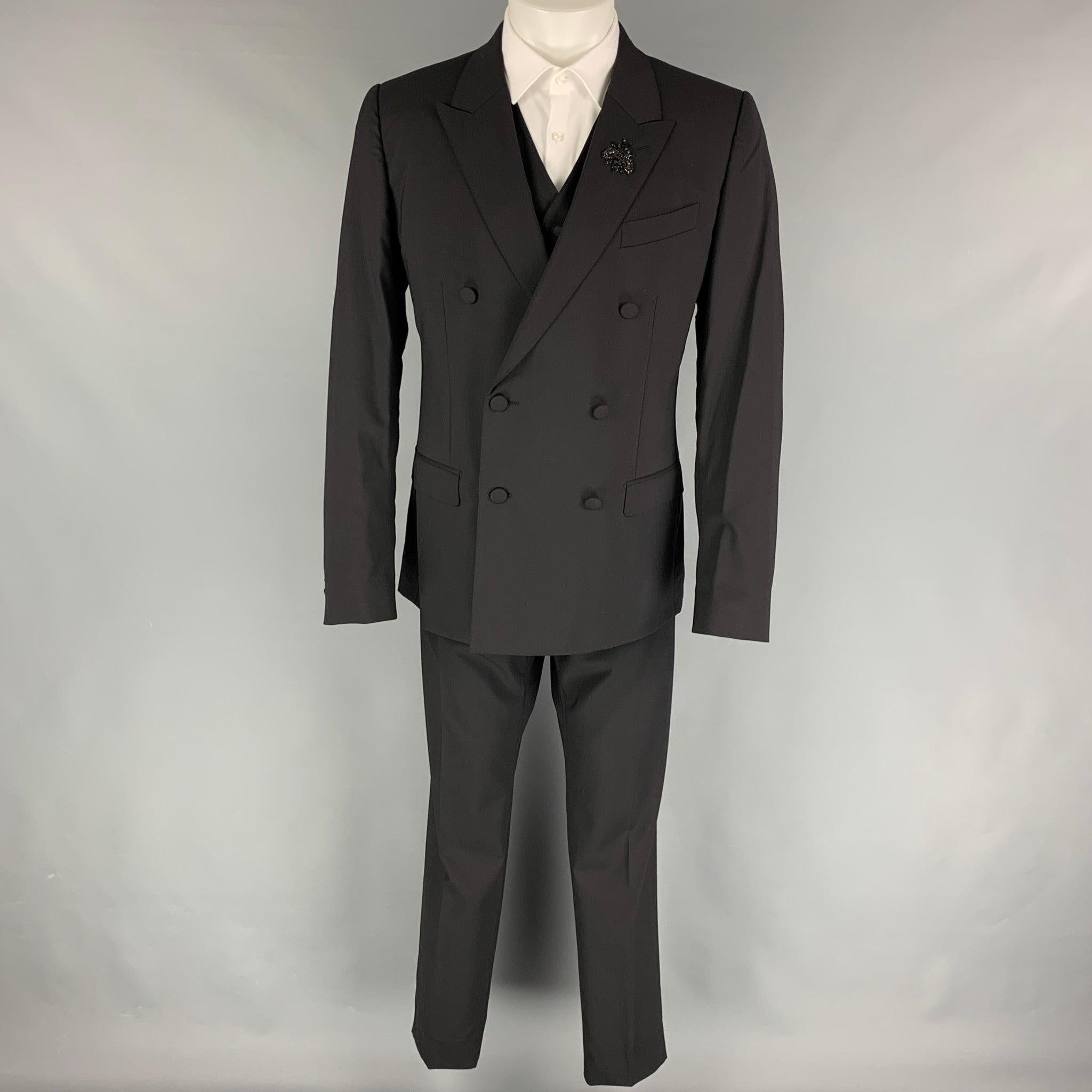 Le costume 3 pièces 'Martini' de DOLCE & GABBANA est en laine vierge noire avec doublure intégrale et comprend un manteau sport à double boutonnage avec revers en pointe, orné de cristaux perlés, et une veste en cuir.
 un gilet assorti et un