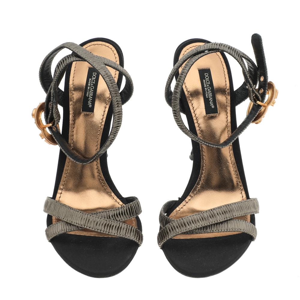Define your feet with these Dolce & Gabbana sandals. The shoes are made of lurex fabric and have open toes and Devotion motif buckle closure. Slim heels complement the design beautifully.

Includes: Original Dustbag