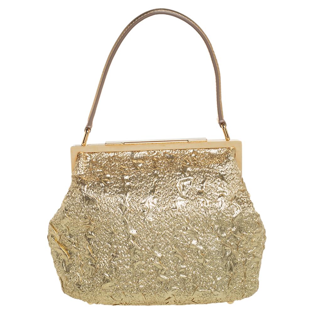 An essential wardrobe accessory, this Dolce & Gabbana bag is surely a must-have. Crafted in Italy, it is made of brocade fabric with a farmed top. It comes in a stunning hue of metallic gold. It exudes glamour and style and is equipped with a single