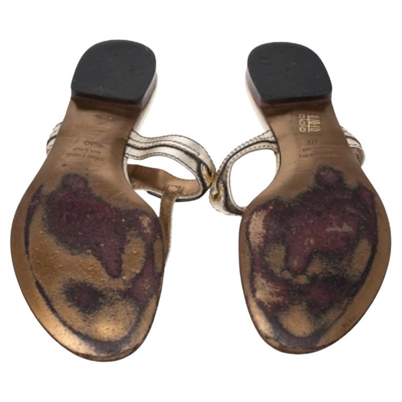 Questi sandali infradito, eleganti e pratici, provengono dalla casa Dolce & Gabbana. Realizzate in pelle di qualità, sfoggiano una tonalità oro metallizzato che aggiunge un tocco di glamour. Presentano il logo del marchio in tonalità oro sui