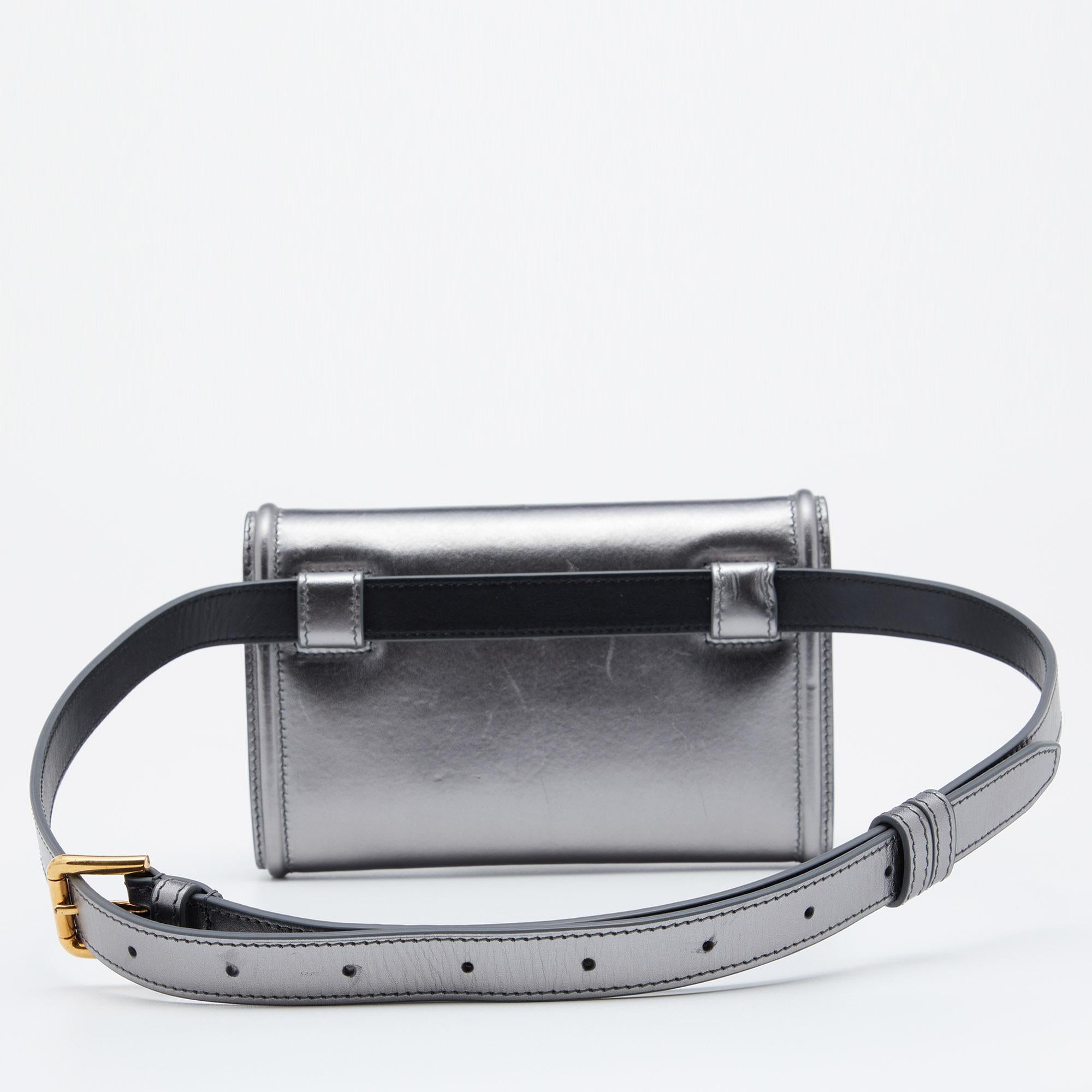 Be a part of the latest trends with this amazing belt bag from Dolce & Gabbana. Crafted with leather, the metallic grey bag comes with a front flap featuring the Devotion heart motif. Equipped with a leather-lined interior and an adjustable belt,