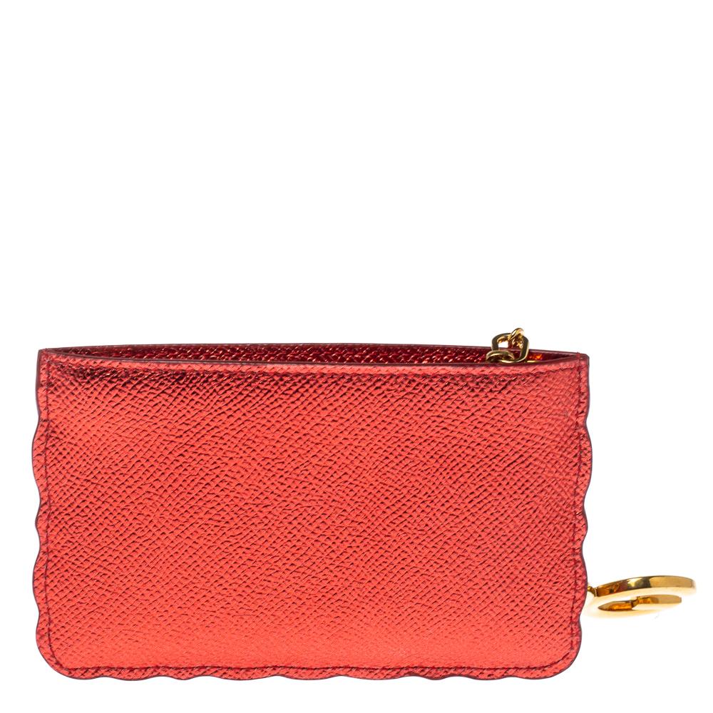 This stylish coin purse by Dolce & Gabbana is a great way to make a statement. It is crafted in Italy and made from quality leather. It comes in a shade of metallic red and flaunts a playful front with the word 'boom.' It opens to a nylon interior