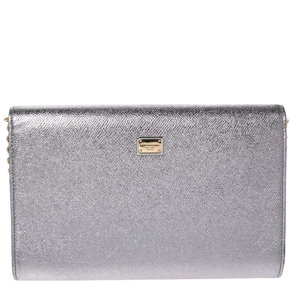 This Dolce & Gabbana clutch is crafted from leather. It has a simple silhouette and features 'MILLENIALS' on the front flap. With a leather-lined interior, the bag has a zip pocket and enough space to house your necessities. It is held by a long