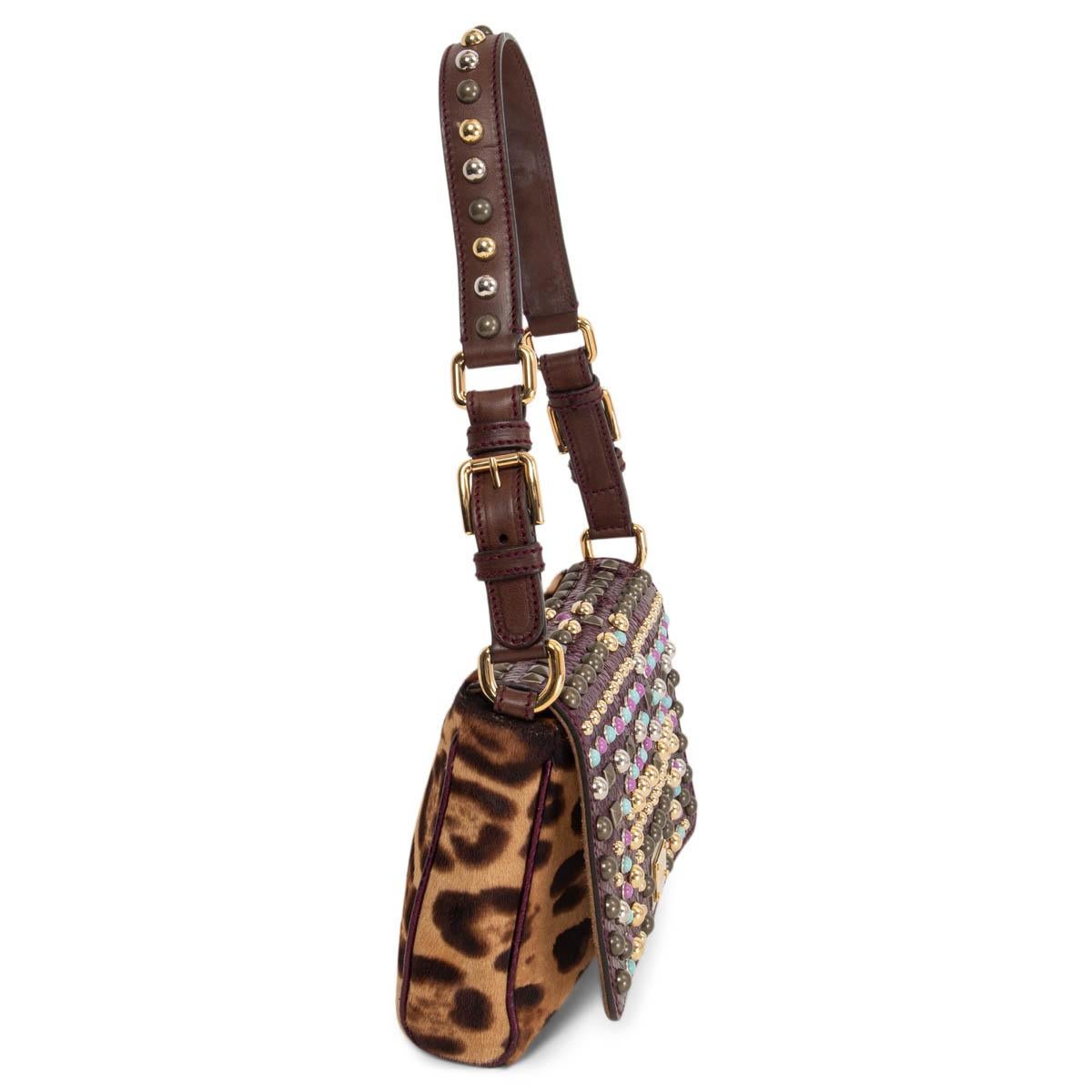 100% authentic Dolce & Gabbana shoulder bag in beige and brown leopard printed calf hair and a shiny purple python embossed studded leather flap with a brown studded shoulder-strap. Opens with a magnetic button under the flap to a black satin