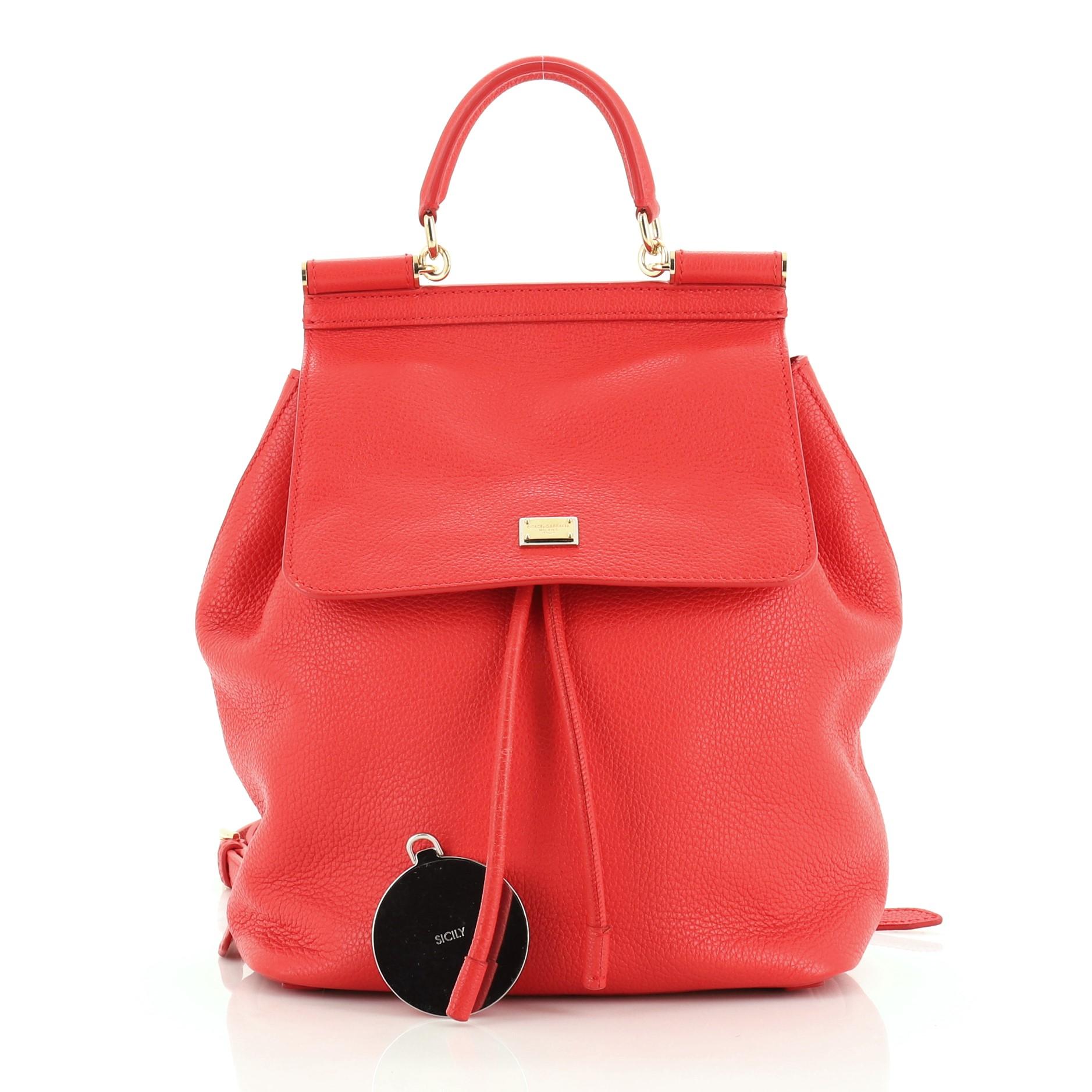 This Dolce & Gabbana Miss Sicily Backpack Leather Mini, crafted from red leather, features leather top handle, adjustable shoulder straps, designer plaque, and gold-tone hardware. Its framed top flap with magnetic snap and drawstring closure opens