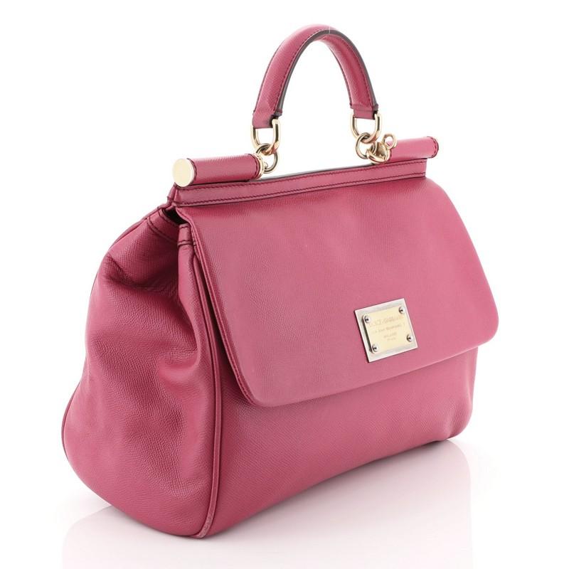 This Dolce & Gabbana Miss Sicily Bag Leather Large, crafted in pink leather, features a leather top handle and gold-tone hardware. Its framed top flap with magnetic snap closure opens to a brown printed fabric interior with zip and slip pockets.