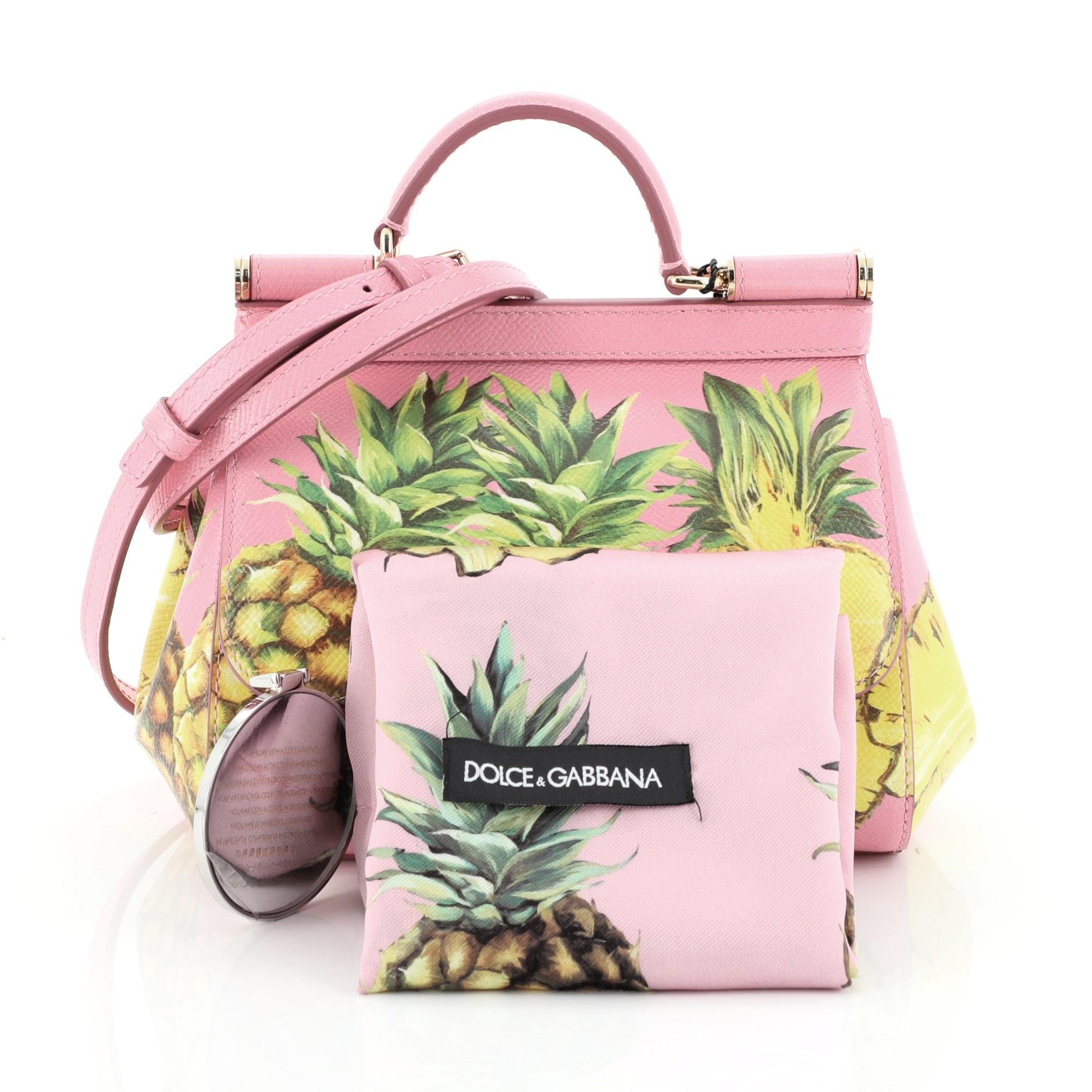 This Dolce & Gabbana Miss Sicily Bag Printed Leather Mini, crafted in pink printed leather, features a single looped leather handle, frontal flap, protective base studs and gold-tone hardware. Its hidden magnetic snap closure opens to a pink leather