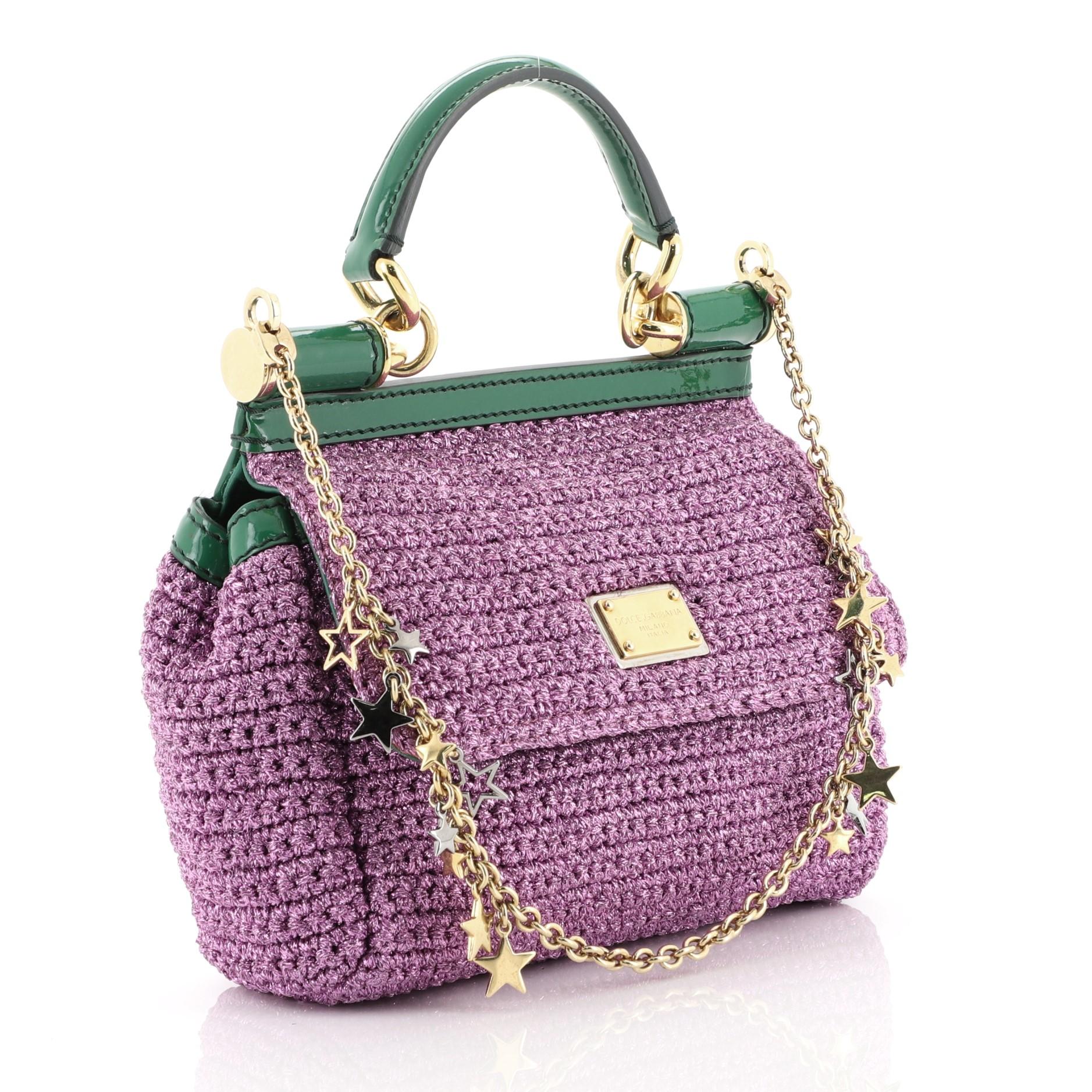 This Dolce & Gabbana Miss Sicily Bag Woven Raffia Small, crafted from purple woven raffia, features a leather top handle, leather trim, and gold-tone hardware. Its framed top flap with magnetic snap closure opens to a brown printed fabric interior