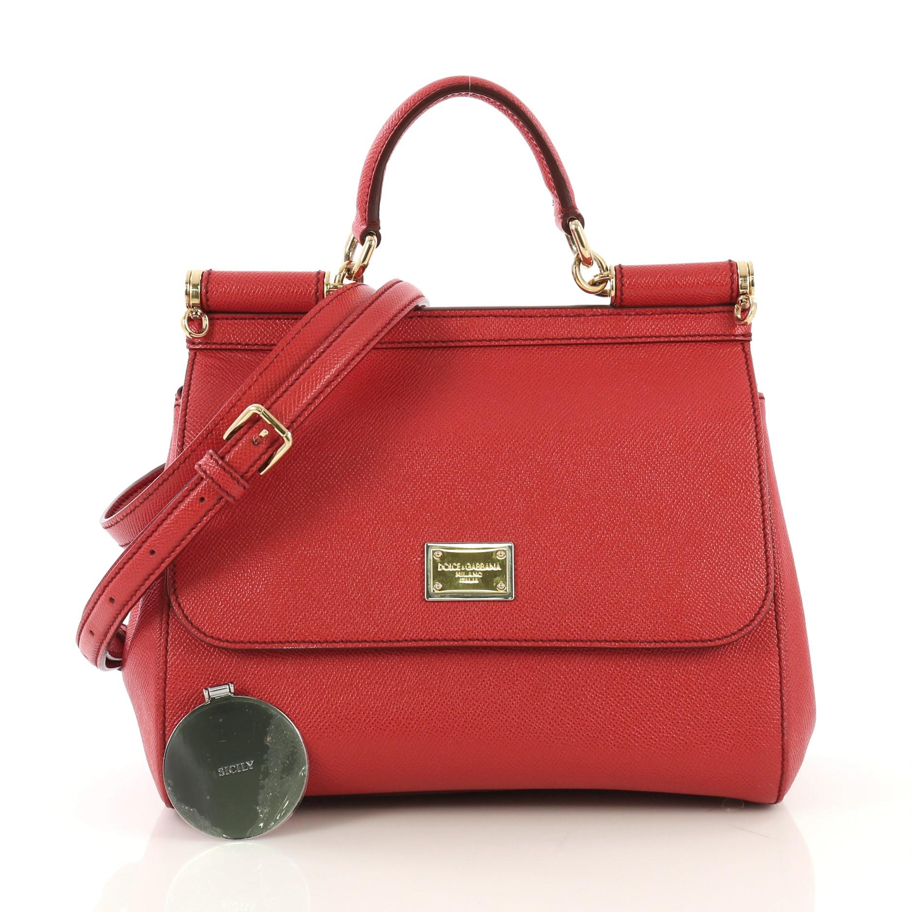 This Dolce & Gabbana Miss Sicily Handbag Leather Medium, crafted in red leather, features a leather top handle, protective base studs, and gold-tone hardware. Its framed top flap with magnetic snap closure opens to a brown leopard printed fabric