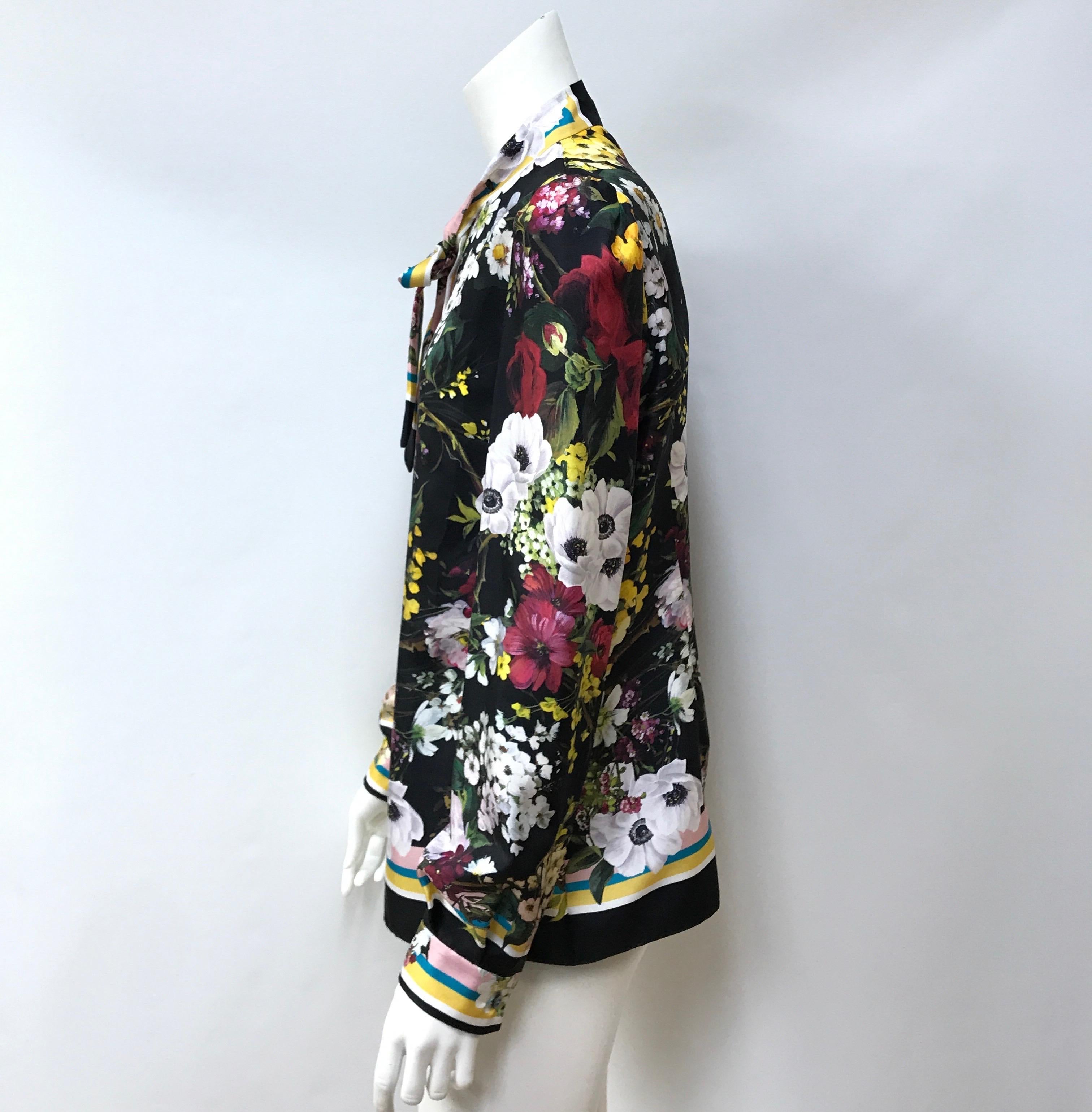 Dolce & Gabbana Multi Color Silk Floral Top-44. This Dolce & Gabbana top is in excellent condition. They are new with tags. This top is made of silk throughout and is black with a multi colored floral pattern. It is long sleeve with buttoned cuffs.