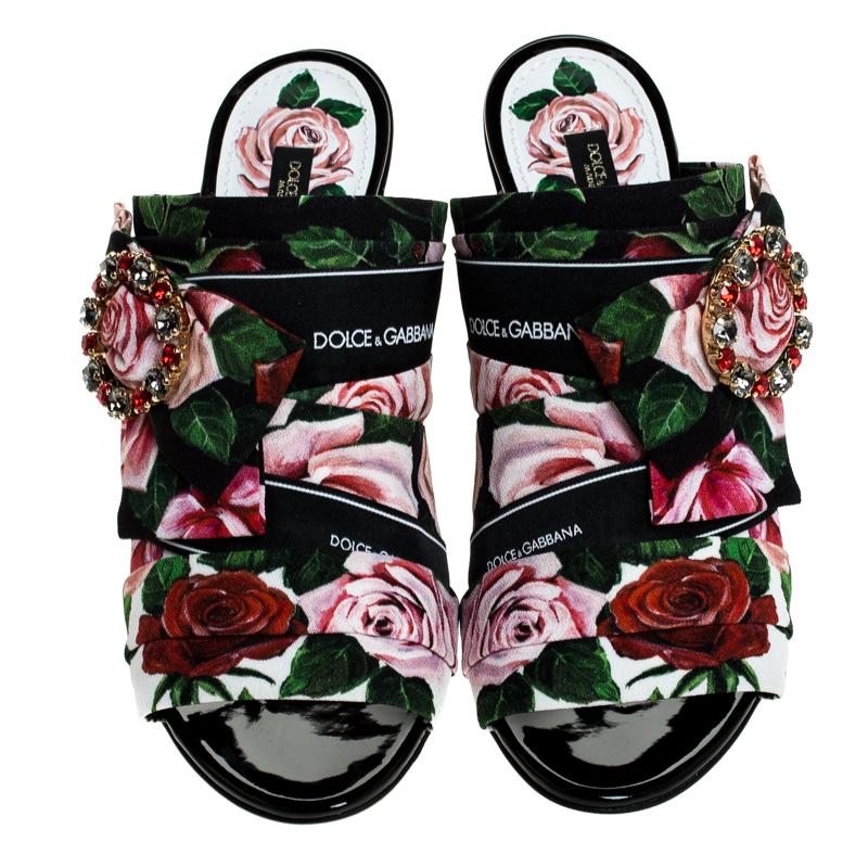 Bold, beautiful and breathtaking, these Dolce & Gabbana mules are made to enchant! They have been crafted from floral-printed fabric and flaunt open toes and bejeweled buckles on the uppers. Comfortable leather-lined insoles and 11 cm block heels