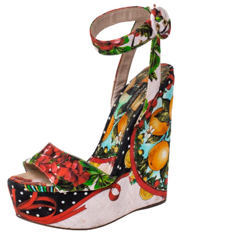 We adore this pair of sandals from Dolce and Gabbana from their shape to their overall appeal. Beautifully crafted from foulard fabric in a burst of floral prints, the sandals feature open toes, ankle straps and are elevated on 14.5 cm wedges. They