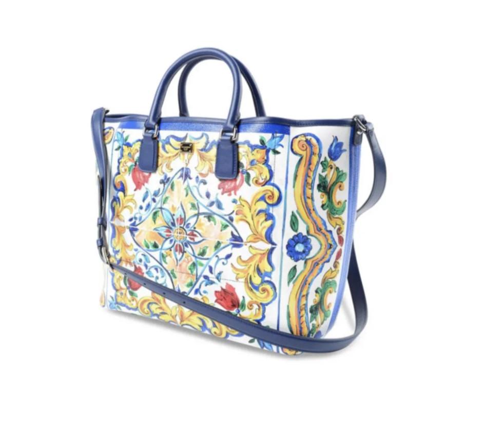 Dolce & Gabbana Iconic Lambskin open top shopper tote detailed with recurring Majolica print, metal logo plaque and hardware, contrasting leather piping, double padded handles and adjustable shoulder strap. Unlined inner featuring two printed patch