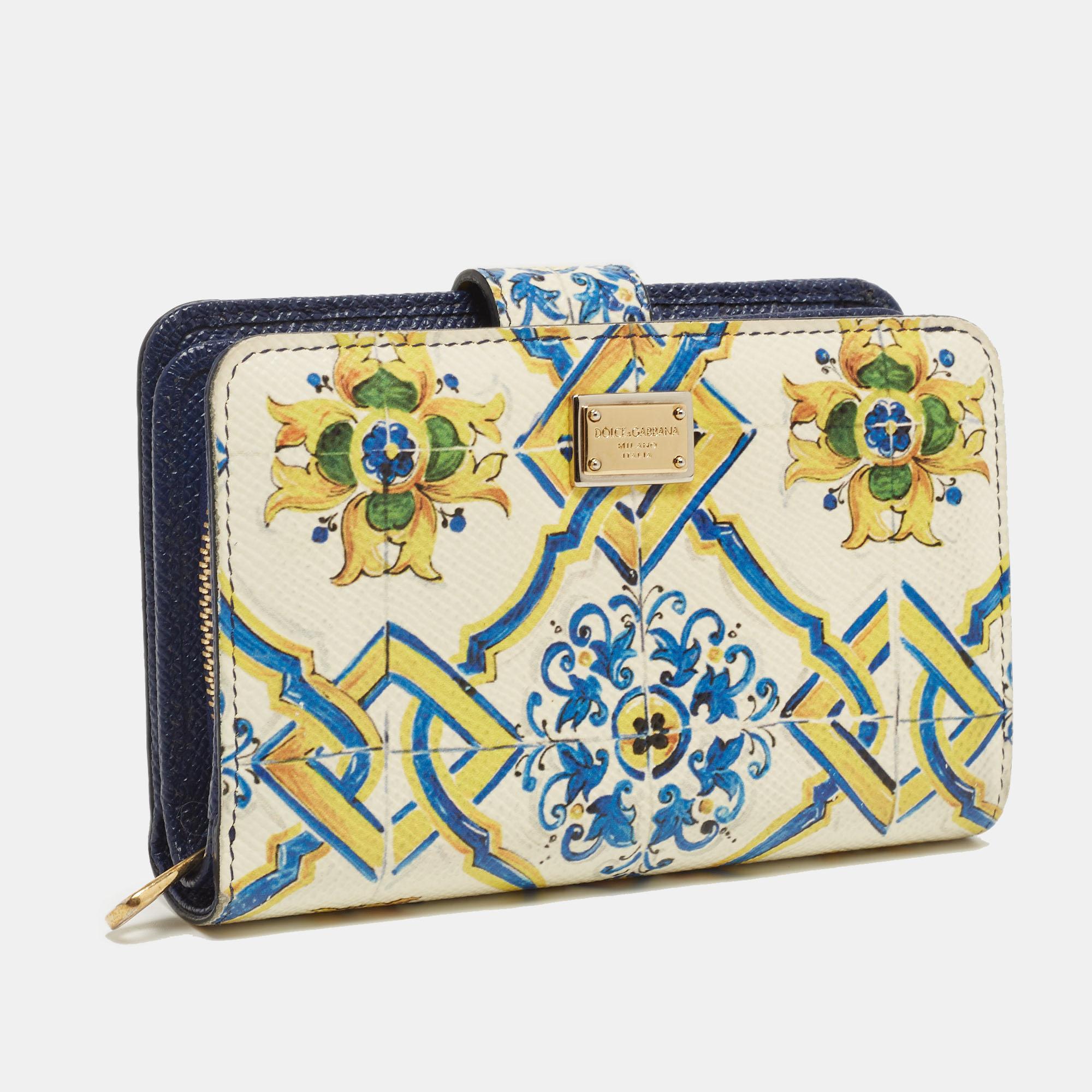 From the house of Dolce & Gabbana comes this fabulous French wallet that is functional and stylish. It is made from white leather accented with a multicolored Majolica print all over and lined with leather on the insides. The wallet comes with two