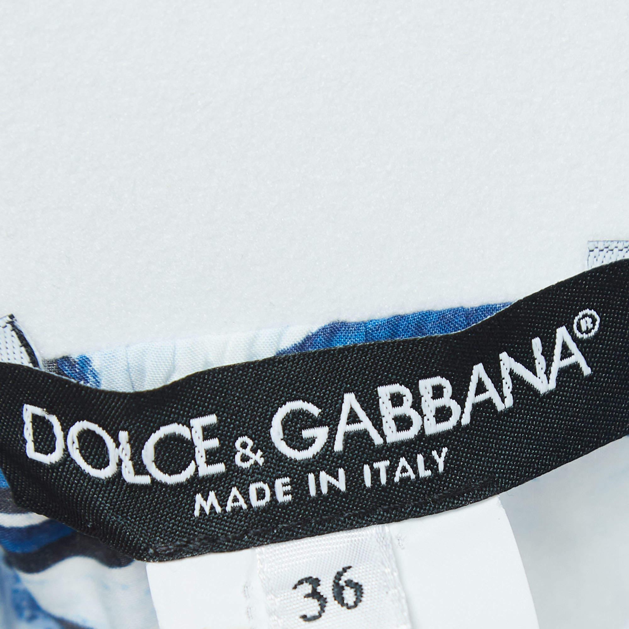 The Dolce & Gabbana maxi skirt is a stunning piece of fashion artistry. Crafted from luxurious cotton, it features a vibrant and intricate majolica print, cascading into tiered layers that gracefully sway with every step, exuding elegance and