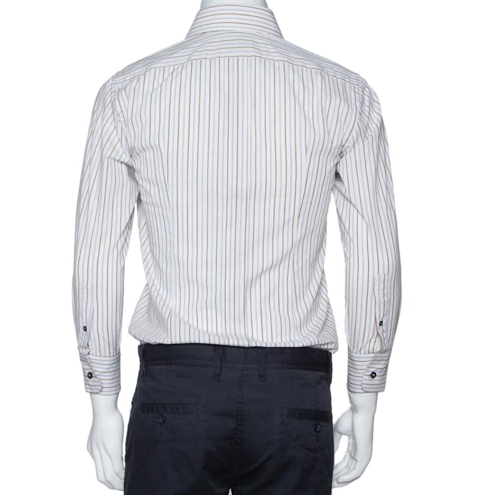 Perfetta per l'ufficio, questa camicia di Dolce & Gabbana è una dichiarazione di forza. È stato realizzato in cotone. È disponibile in tonalità multicolore e presenta un esterno a righe. Ha maniche lunghe, bottoni sul davanti, un colletto semplice