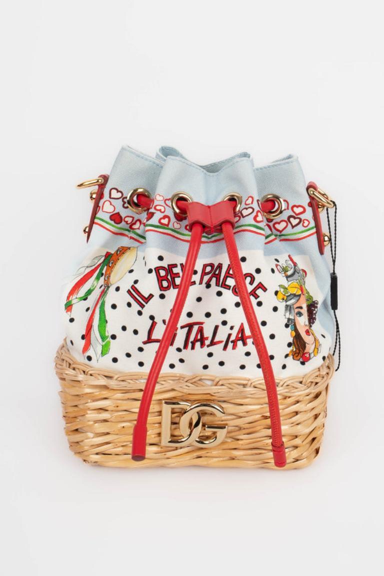 Dolce & Gabbana -  (Made in Italy) Multicolored canvas bag, wicker bottom, red leather and gold metal attributes. Authenticity card present.

Additional information: 
Condition: Very good condition
Dimensions: Height: 22 cm - Length: 17 cm - Depth: