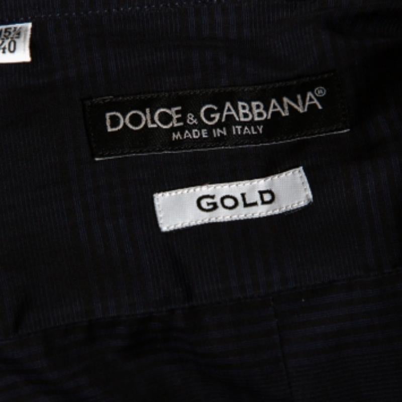 Les chemises sont un élément indispensable de la garde-robe d'un homme, c'est pourquoi Dolce & Gabbana vous propose une création à la fois polyvalente et élégante. Il a été confectionné en coton dans une teinte bleu marine. La chemise est ornée de