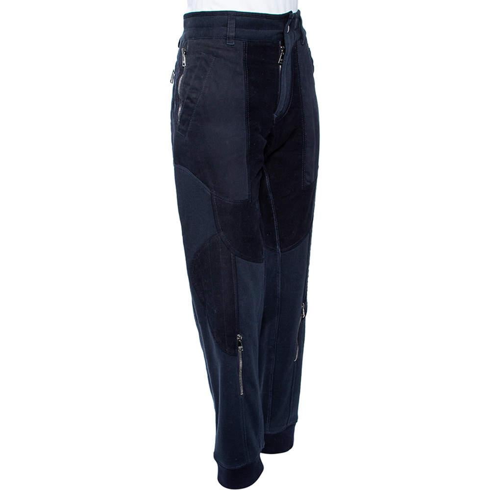 Now lounge around in comfort in these sweatpants from Dolce and Gabbana. The navy blue pants are made of a quality cotton blend and feature a paneled design with zip accents. They flaunt four pockets.