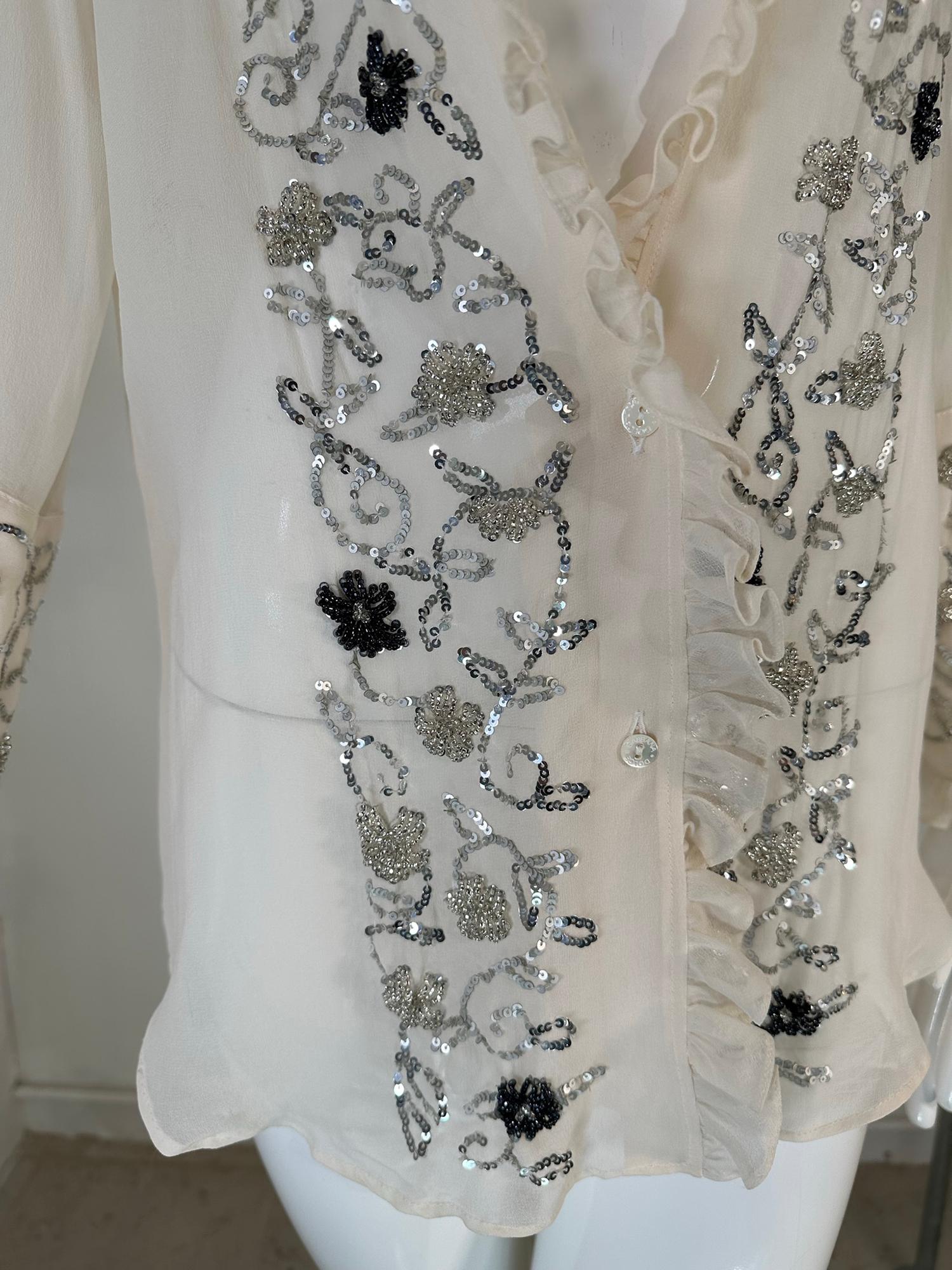 Dolce & Gabbana off white sheer silk chiffon plunge neck glittery sequin blouse 44. Sheer silk chiffon blouse with deep plunge neckline that is outlined with narrow ruffles & a wing collar. The long sleeves have deep cuffs with ruffle edges & sequin