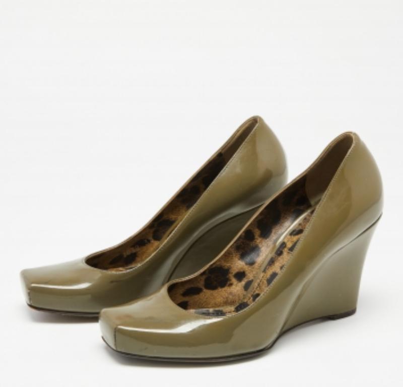 Classy and stylish pumps like these from the House of Dolce & Gabbana are a closet essential. They are created using olive-green patent leather on the exterior. They feature covered toes, wedge heels, and a slip-on feature. Add these pumps to your