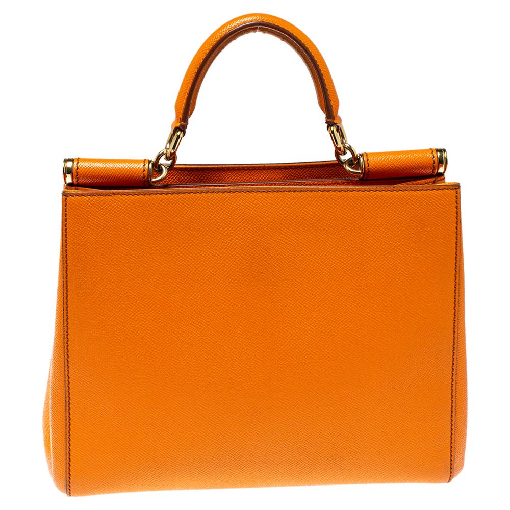 Coming from the Miss Sicily collection, this Dolce & Gabbana shopper bag is the perfect everyday bag. The orange leather exterior is accentuated with gold-tone hardware. The structured top has a single handle, giving the bag a signature elegant