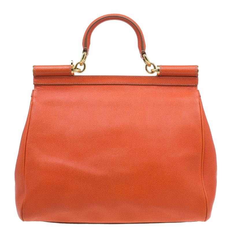Part of the Miss Sicily collection, this Dolce and Gabbana tote is the perfect everyday bag. Crafted with textured orange leather, it comes accented with gold-tone hardware. With a structured top, it has a sturdy top handle, a flap opening with a