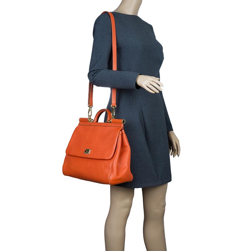 Part of the Miss Sicily collection, this Dolce and Gabbana tote is the perfect everyday bag. Crafted with textured orange leather, it comes accented with gold-tone hardware. With a structured top, it has a sturdy top handle, a flap opening with a