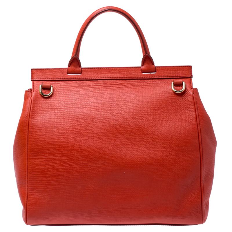 Well-structured and high on style, this Miss Monica bag from Dolce and Gabbana deserves to be yours! It has been crafted from orange leather and styled with a top handle and a detachable shoulder strap. It also comes with a gold-tone latch-lock flap