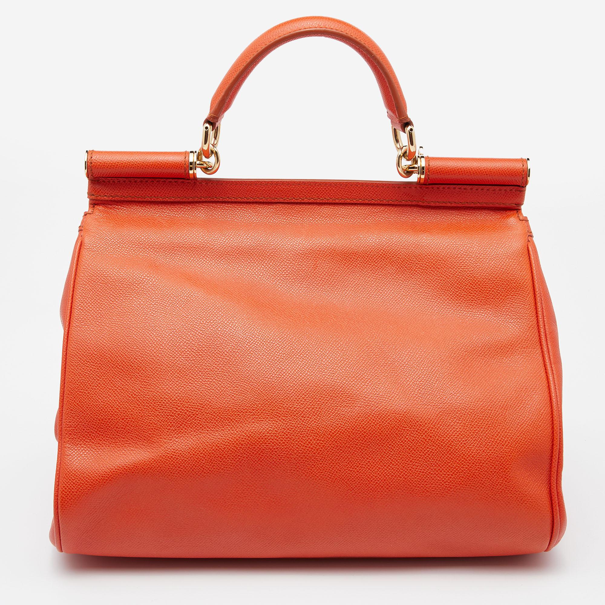 The iconic Miss Sicily bag by Dolce & Gabbana is one of the most loved designs from the brand. The charming silhouette of this version is made from sprightly orange leather and features a front flap carrying the logo plaque. The luxurious creation