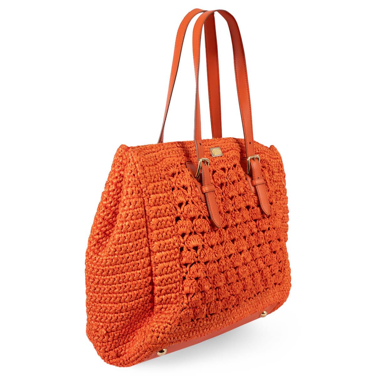 100% authentic Dolce & Gabbana Alma tote in orange Raffia crochet with gold-tone hardware. It features two top handles, a red fabric-lined interior with one zipper pocket against the back and two open pockets against the front. Has been carried and