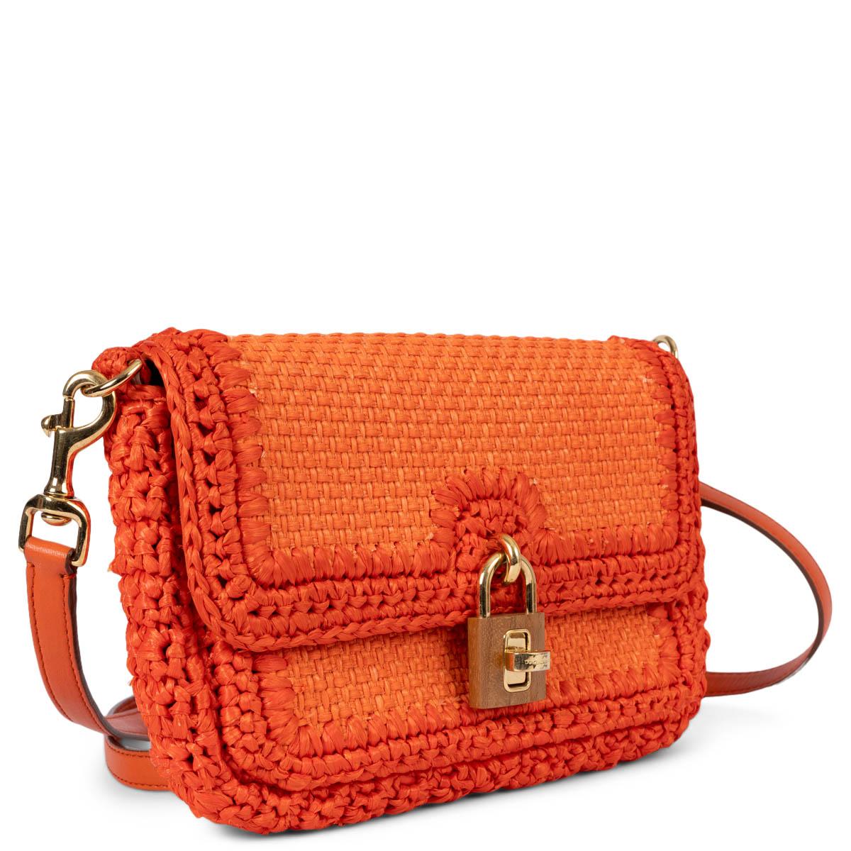 100% authentic Dolce & Gabbana Miss Bonita shoulder bag in orange raffia. The design features a gold-tone metal and wood padlock and is lined in classic leopard print canvas with one zipper pocket against the back. Come with an adjustable and