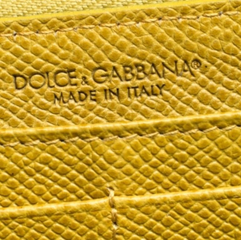 Este precioso accesorio procede de la casa Dolce & Gabbana. Fabricado en Italia, está confeccionado en piel Paglia y se presenta en un impresionante tono amarillo. Esta cartera tiene un cierre de cremallera que se abre para revelar un interior