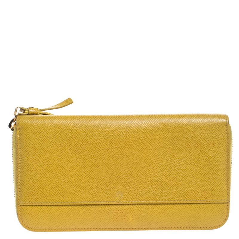 This lovely accessory comes fro the house of Dolce & Gabbana. Crafted in Italy, it is made from Paglia leather and come in a stunning shade of yellow. This wallet has a zip closure that opens to reveal a leather-lined interior with multiple card