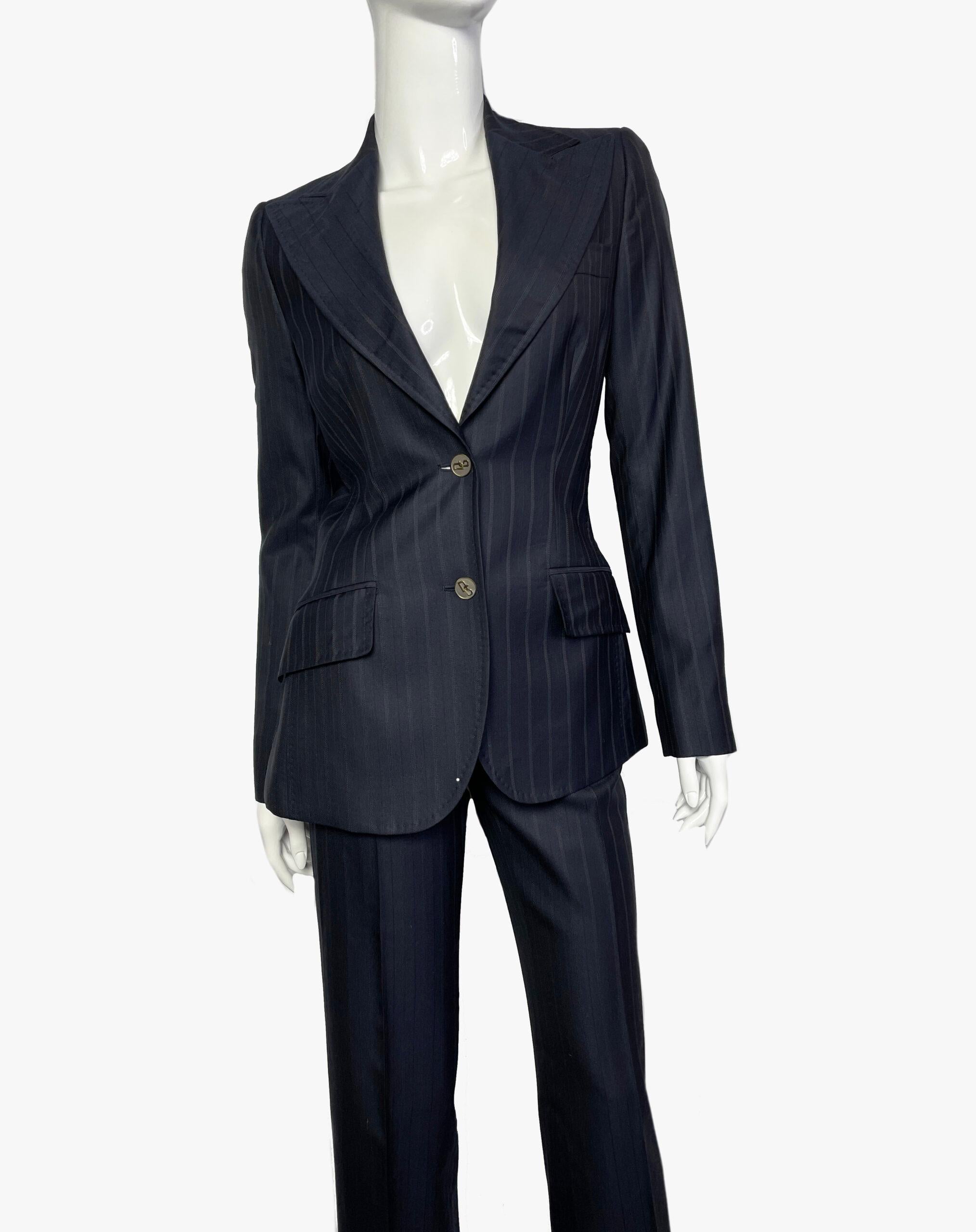 Trouser suit in fine wool and silk, perfect fit and cut. Dark blue color with pinstripe print. The jacket has two pockets and fastens with buttons. A row of buttons on the sleeve. Fully lined. 
Trousers are straight, there are loops for a belt.