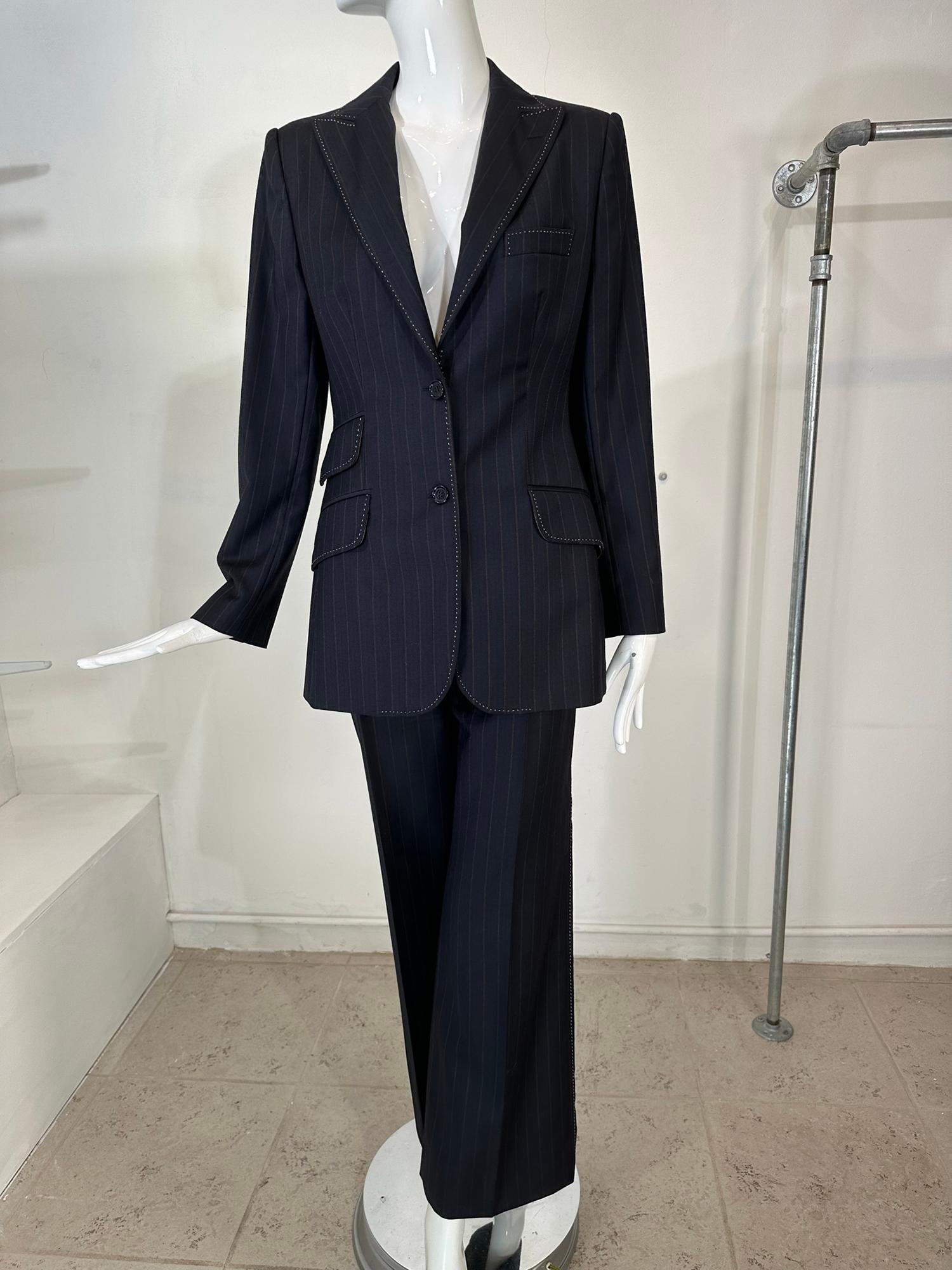 Dolce & Gabanna pin stripe fine wool single breasted jacket & full leg pant suit. This stylish suit features a slim fitting slightly below hip length jacket with with hip front flap pockets 2 on the right & 1 on the left. Deep V neckline with