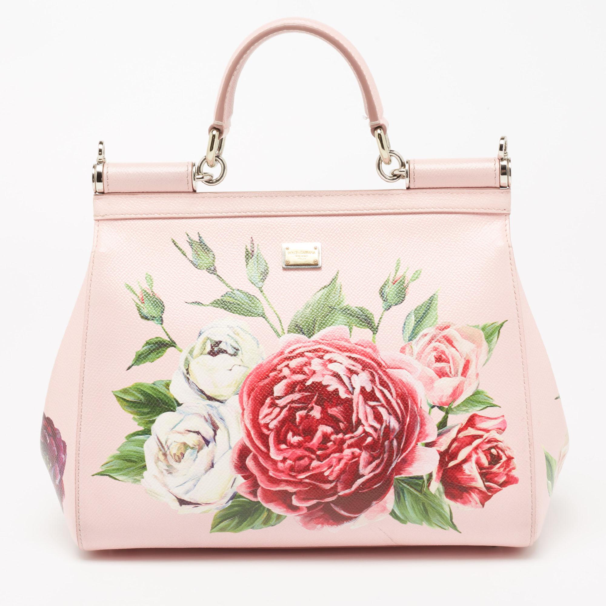 Meticulously crafted into an eye-catchy shape, this Miss Sicily bag from the House of Dolce & Gabbana exudes just the right amount of charm and elegance! It is made from pink floral-printed leather on the exterior. It has a fabric-lined interior,