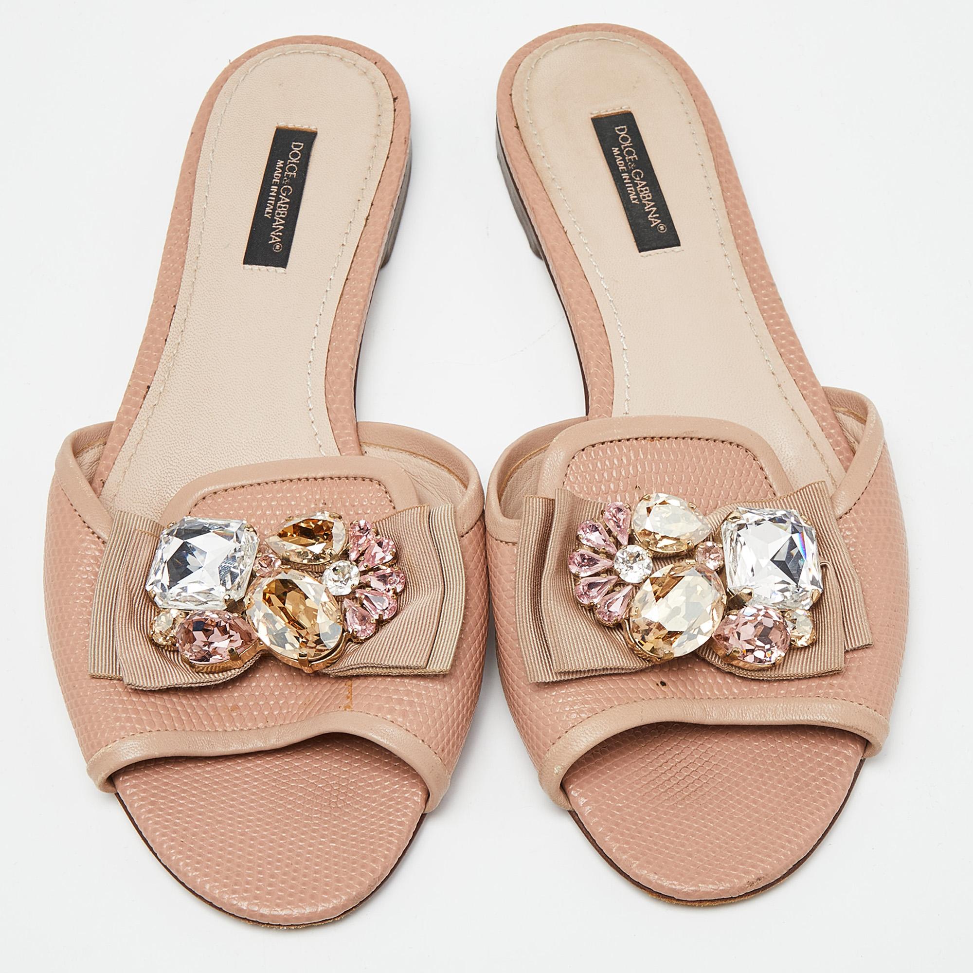 Present your feet with utmost comfort by choosing these flat slides from the house of Dolce & Gabbana. They are crafted from lizard-embossed leather and detailed with a crystal-embellished bow on the uppers. They are complete with durable outsoles.

