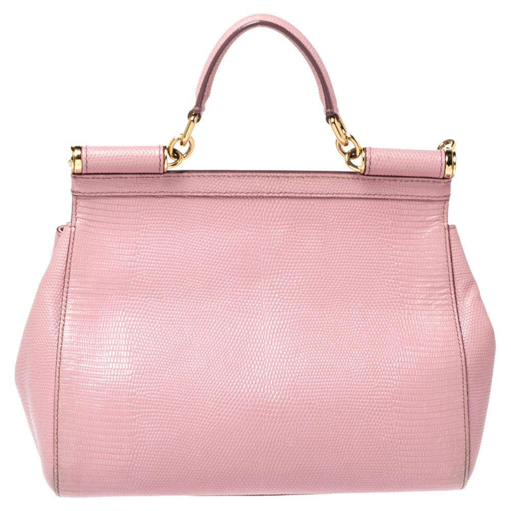 This gorgeous Miss Sicily bag from Dolce & Gabbana is a handbag coveted by women around the world. Crafted from lizard-embossed leather, it has a pink exterior. The bag opens to a compartment with fabric lining and enough space to fit your