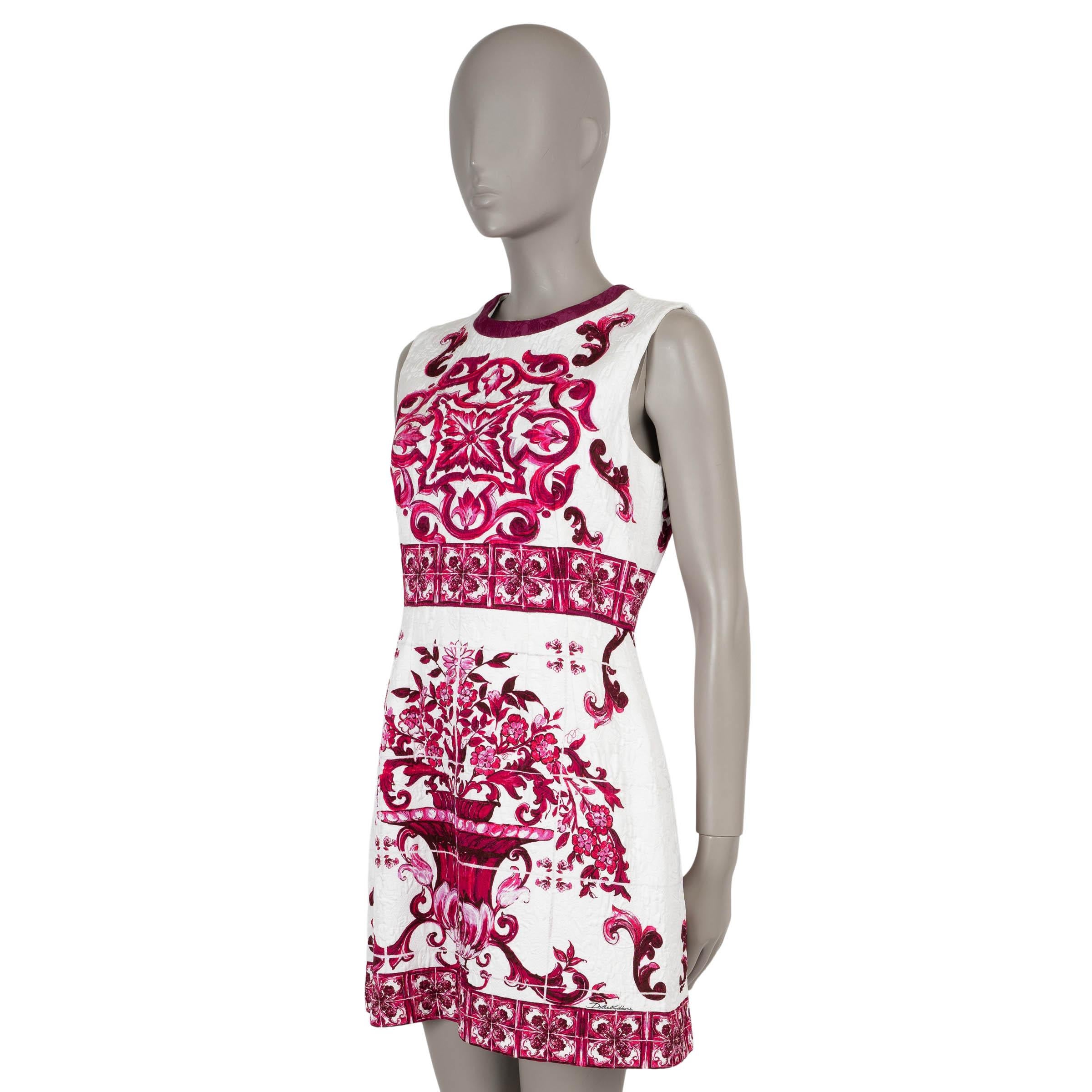 This 100% authentic Dolce & Gabbana dress in white brocade silk (with 9% elastane) is a vibrant statement piece, adorned with a striking fuchsia pink Majolica print. Designed with a sleeveless fit and flare silhouette, it features a flattering mini