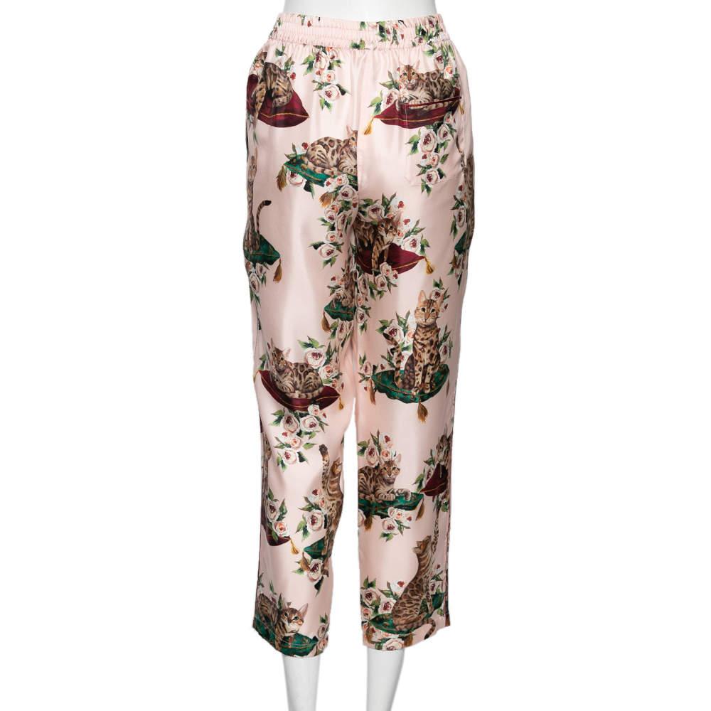 In dieser Pyjamahose von Dolce & Gabbana fühlen Sie sich pudelwohl. Die Seidenkreation ist über und über mit einem hübschen Blumen- und Katzenprint versehen und hat Taschen. Kombinieren Sie die rosafarbene Hose mit Pantoletten für einen schicken