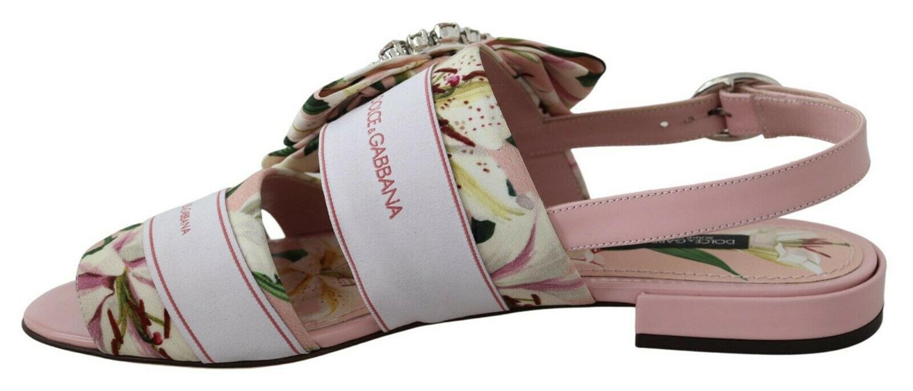 Gorgeous, brand new with tags 100% Authentic Dolce & Gabbana flats chose a dense lily print cady to create these light pink Bianca sandals. The romanticism of the pattern was supported by a bow, gathered with a crystal buckle.

Model: Sandals