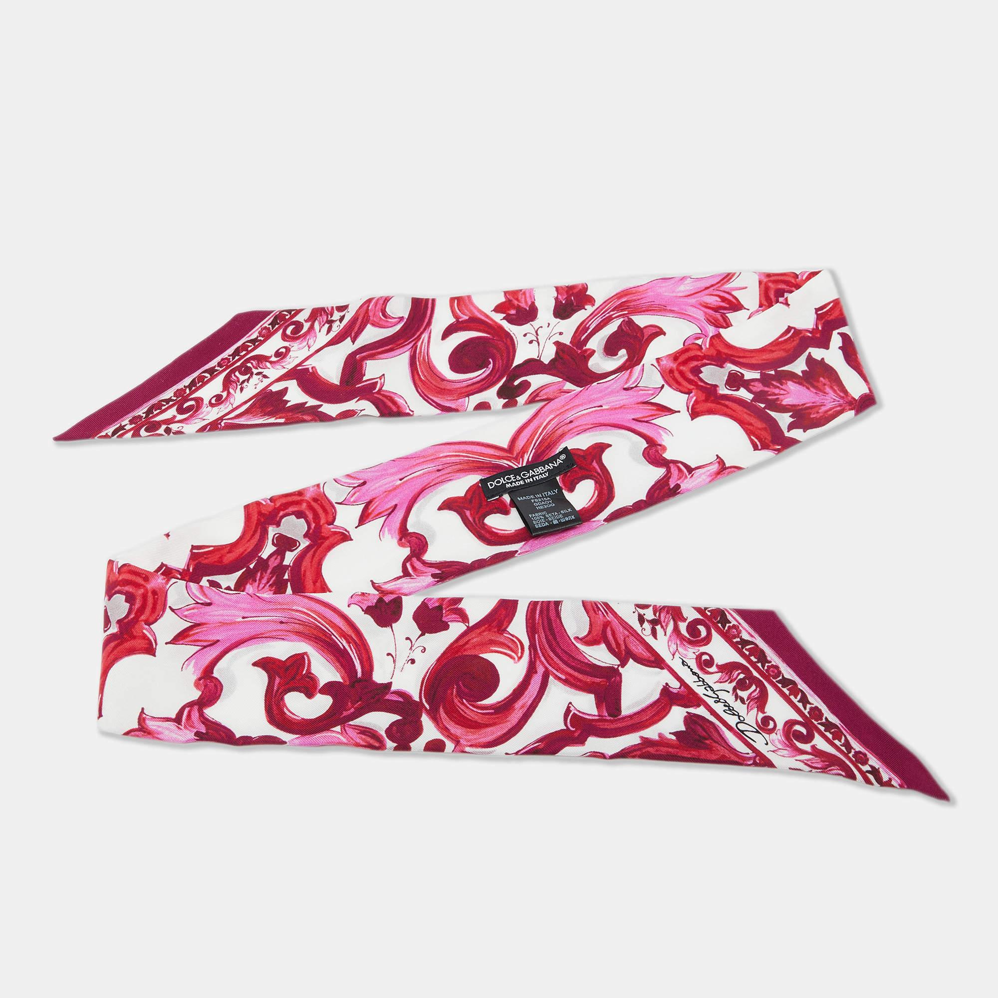 Este pañuelo bandeau de seda de Dolce & Gabbana presenta el característico estampado Majolica de la marca en rosa y blanco. Confeccionado en lujosa seda  añade un toque de elegancia con su intrincado diseño inspirado en la cerámica tradicional