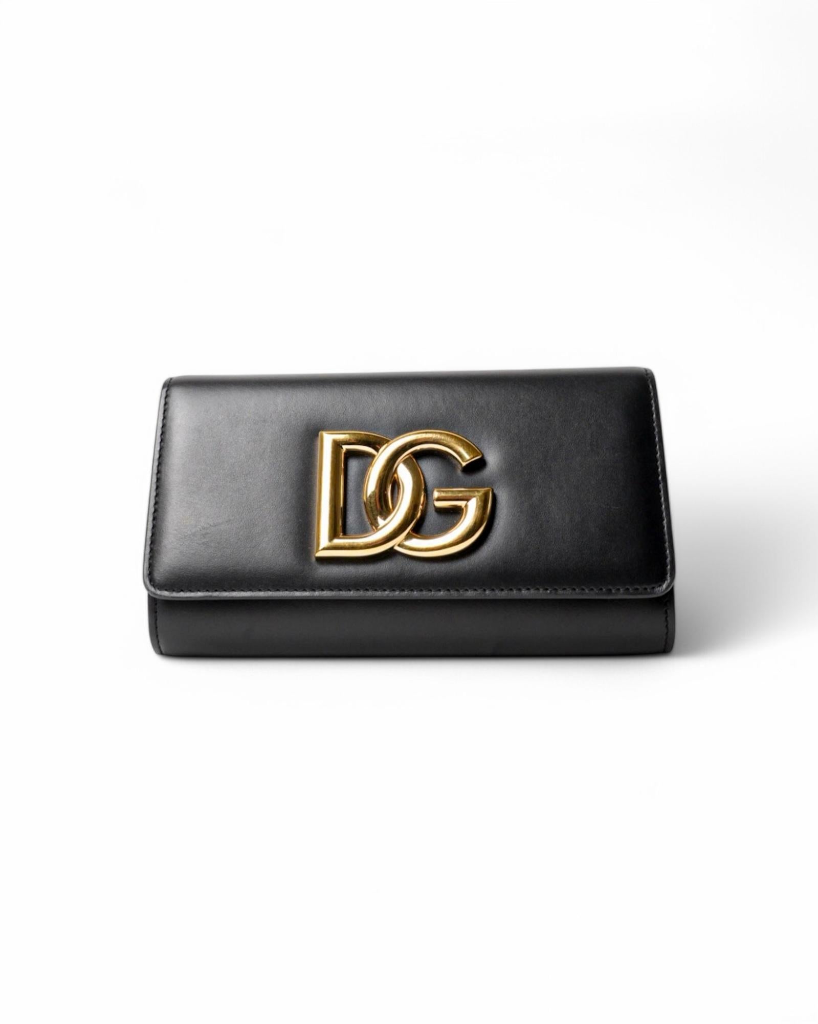 Dolce & Gabbana signature clutch bag, line 3.5, made of smooth black leather with gold hardware details. Featuring a front flap with the classic gold metal 'DG' logo and a magnetic button closure, the interior is lined in tone-on-tone leather with a