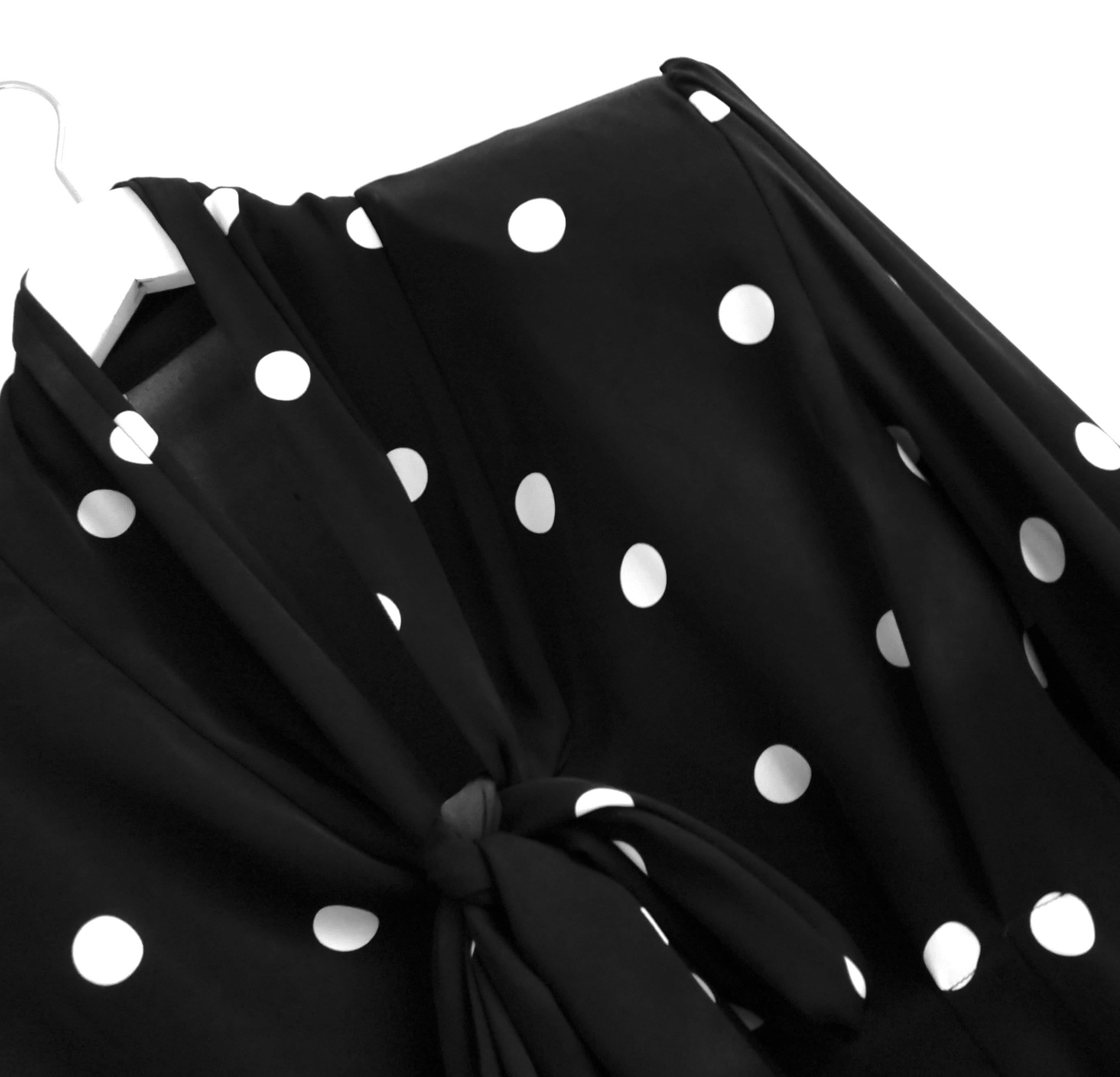 Splendida camicetta con fiocco a pois di Dolce & Gabbana. Comprato per 1250 sterline. Realizzato in morbida seta ed elastan a pois bianchi e neri, ha maniche a sbuffo imbottite e lunghi lacci al collo. Taglia IT38/UK6. Misure circa: busto 32