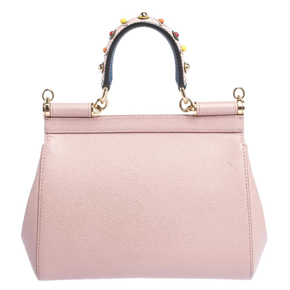 This gorgeous powder pink Miss Sicily satchel from Dolce & Gabbana is a handbag coveted by women around the world. It has a well-structured design and a flap that opens to a compartment with fabric lining and enough space to fit your essentials. The