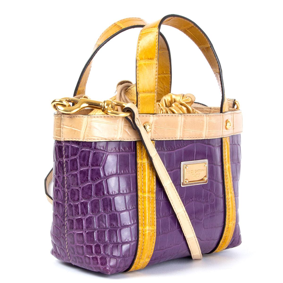 100% authentic Dolce & Gabbana Limited Edition bag in purple, beige and mustard embossed crocodile leather with golden metallic leather lining featuring drawstring closure. Has one zip pocket on the inside and a detachable shoulder strap. Has been