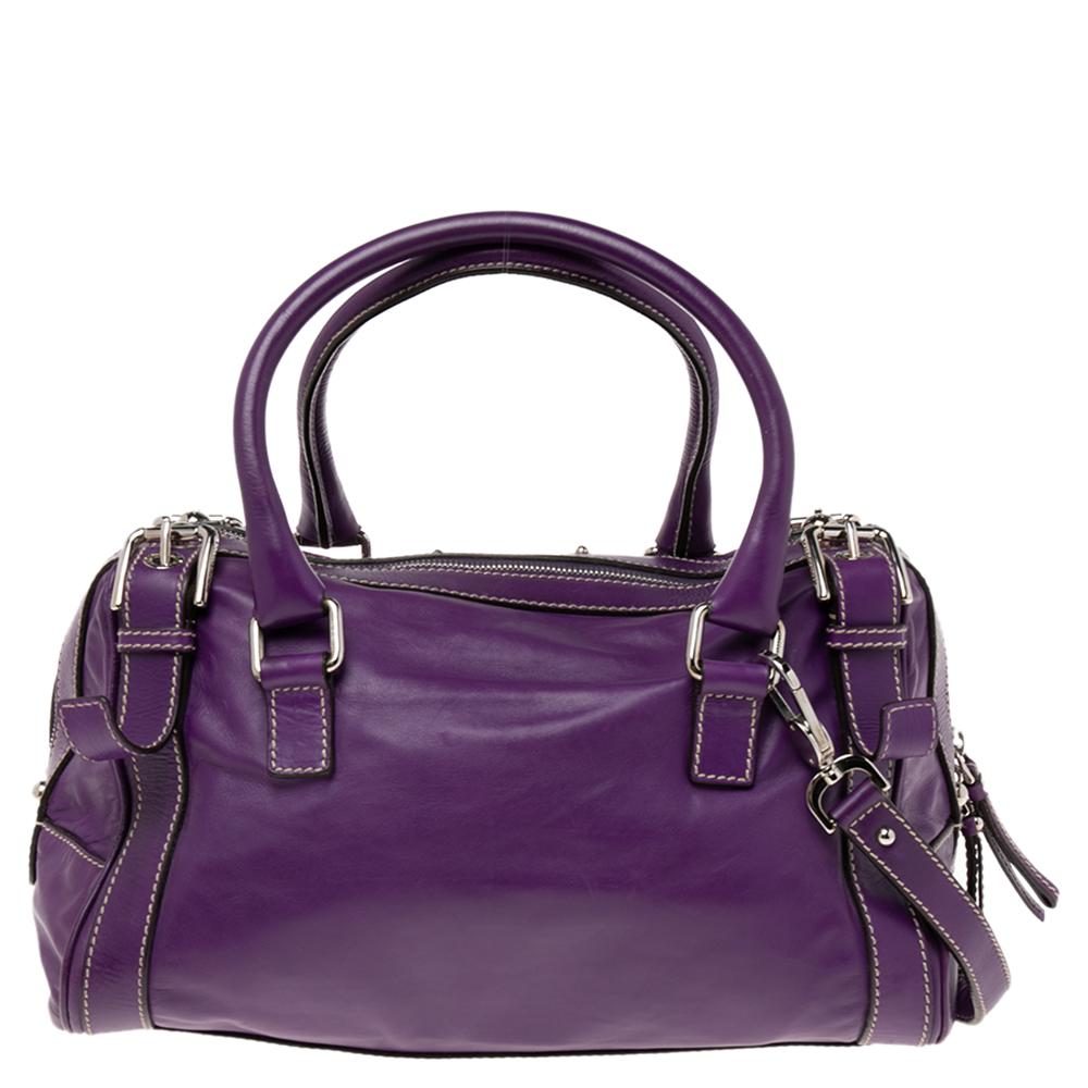 This chic Miss Easy Way Boston Bag by Dolce & Gabbana will complement both your casual and evening wear. Crafted from leather in a purple shade, it is decorated with the brand plaque and a zip pocket at the front. The bag is equipped with two